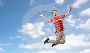 happy smiling young boy jumping over sky