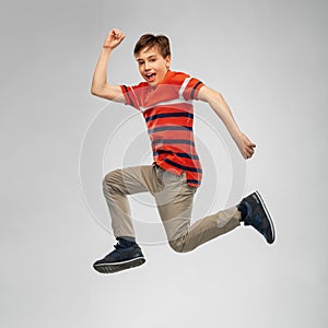 Happy smiling young boy jumping or running in air