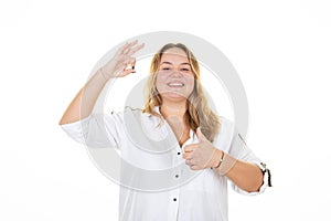 Happy smiling young business woman with fingers okay gesture showing thumb up palm sign on white background