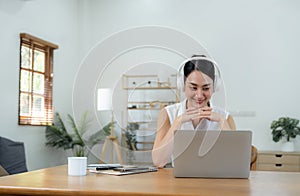Happy smiling young Business woman with headphone in video call on laptop busy talking, concept of online chat, distance