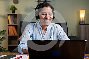 Happy smiling young Business woman with headphone in video call on laptop busy talking - concept of online chat