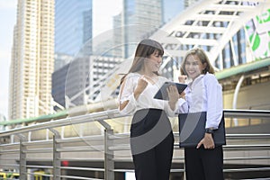 Happy smiling young business women are working in modern city, talking about business plan