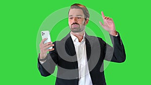 Happy smiling young businessman making a video call on a Green Screen, Chroma Key.