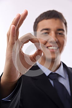 Happy smiling young businessman with okay gesture,