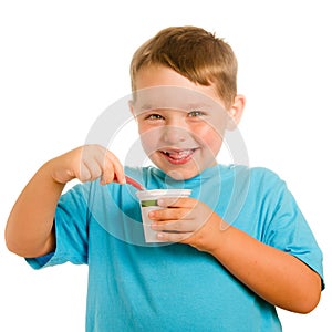 Happy smiling young child eating yogurt