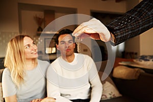 Happy smiling young couple showing a keys of their new house