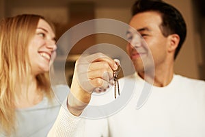 Happy smiling young couple showing a keys of their new house