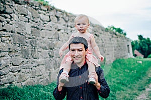 Happy smiling young father with a little cute daughter in pink dress