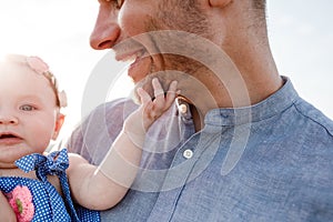 Happy smiling young father and little daughter in his hands having fun outdoors on summer day. family concept. fathers and baby