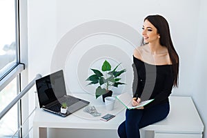 Happy smiling young female student using laptop at library, cheerful hipster girl working on portable computer at vintage