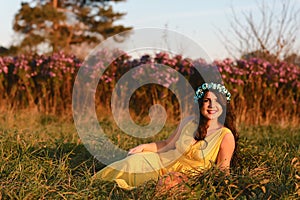 Happy smiling young girl, attractive woman wearing yellow dress, walking in the flower field. Lifestyle concept