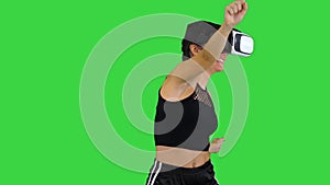 Happy smiling young girl using VR headset glasses playing dancing game First time on a Green Screen, Chroma Key.