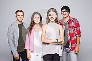 Happy smiling young group of friends standing together isolated on white