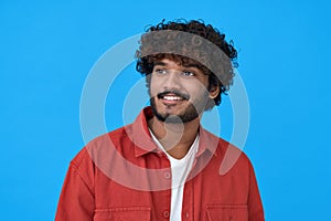 Happy smiling young indian man looking, dreaming on blue background.