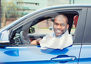 Happy smiling young man buyer sitting in his new car