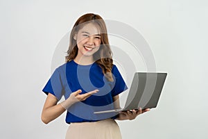 Happy smiling young woman of Asian ethnicity in blue shirt holding work on laptop computer