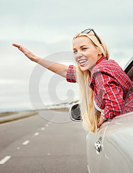 Happy smiling young woman in car window