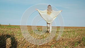 Happy smiling young woman enjoying nature on harvesting field.