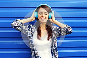 Happy smiling young woman listens and enjoys the music in headphones