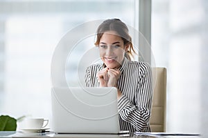 Contento giovane donna guarda computer portatile schermo 
