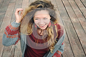 Happy smiling young woman portrait dressed in gray knitted jersey