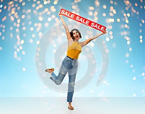 Happy smiling young woman posing with sale banner