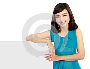 Happy smiling young woman showing blank signboard