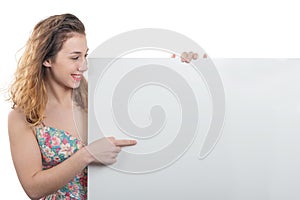 Happy smiling young woman showing empty blank signboard with copyspace