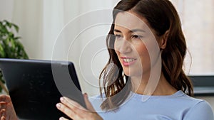 Happy smiling young woman with tablet pc at home
