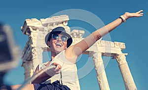 Happy smiling young woman take a selfie photo on antique sights