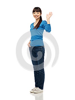 Happy smiling young woman waving hand over white