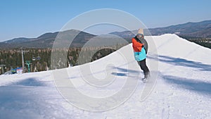 Happy snowboarder having fun snowboarding backcountry on a sunny winter day in snowy mountains. guy in a bright color