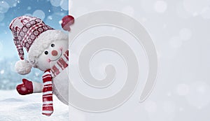 Happy snowman behind the blank banner with copy space