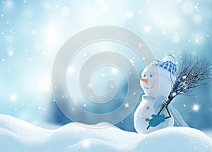 Happy snowman with a broom in hand, standing in Christmas landscape. Snow background. Winter fairytale