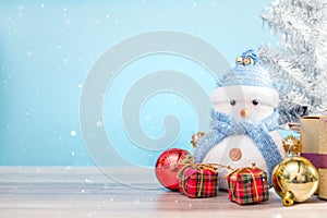 Happy snowman standing in blue winter christmas snow background.