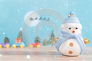 Happy snowman standing in blue winter christmas snow background. Merry christmas and happy new year greeting card with copy-space.