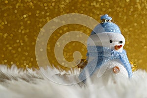 Happy snowman standing in gold winter christmas snow background. Merry christmas and happy new year greeting card with copy-space.