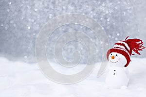 Happy snowman standing in winter christmas landscape. Merry christmas and happy new year greeting card. Funny snowman in hat on