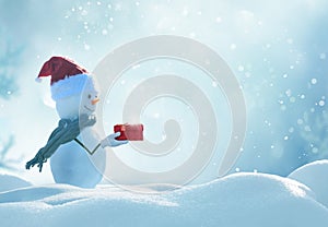 Happy snowman standing in winter christmas landscape.