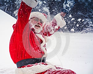 Happy snowy Santa Claus raised his hands up and joyfully shouts hurray.