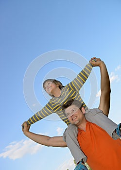 Happy son on the shoulders of the father