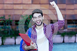 Happy spanish male student cheering about graduation
