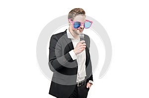 Happy speaker man in funny glasses and formal suit speak to microphone, conferencier