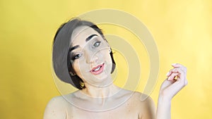 Happy speaking girl on yellow background in 4K