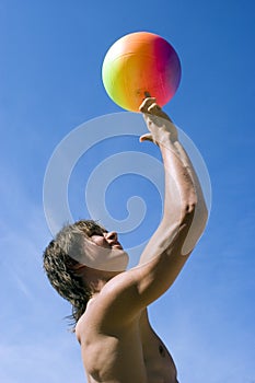 Happy sport build teenager boy with ball in beach