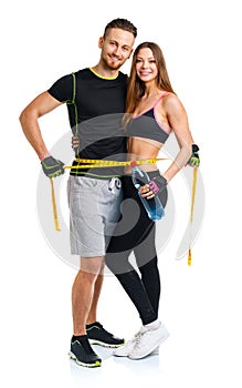 Happy sport couple - man and woman with measuring tape on the white