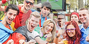 Happy sport fans having fun during football world game - Young supporters at pub outdoor watching soccer match - Friendship and