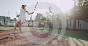 Happy sportiv woman playing tennis at tennis court outside.