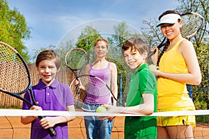 Happy sportive family with tennis apparel