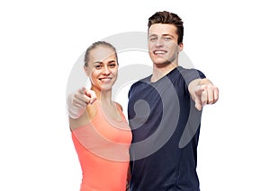 Happy sportive man and woman pointing finger